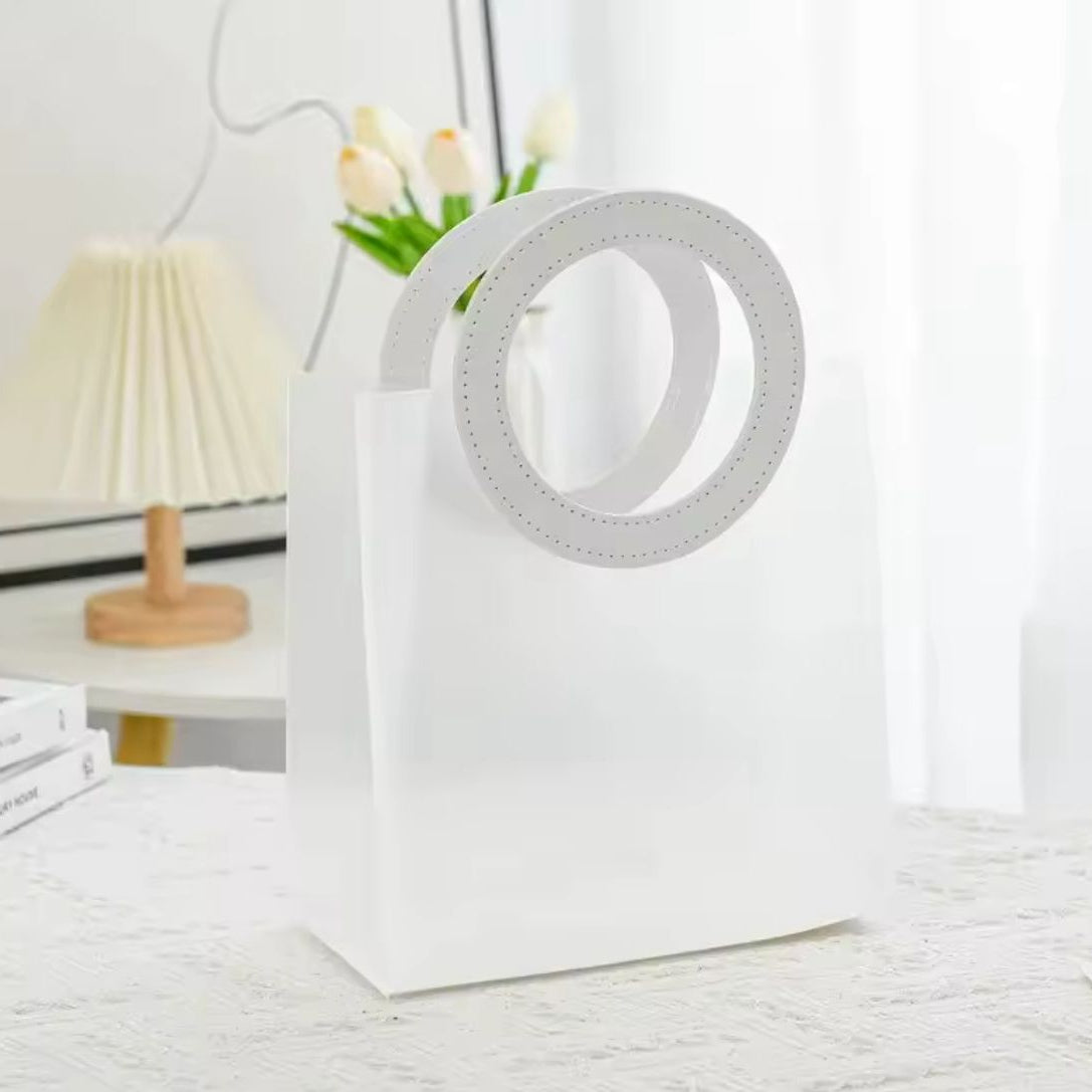 Sac à main transparent élégant avec poignée ronde en cuir coloré, dimensions 18 × 16 × 8 cm